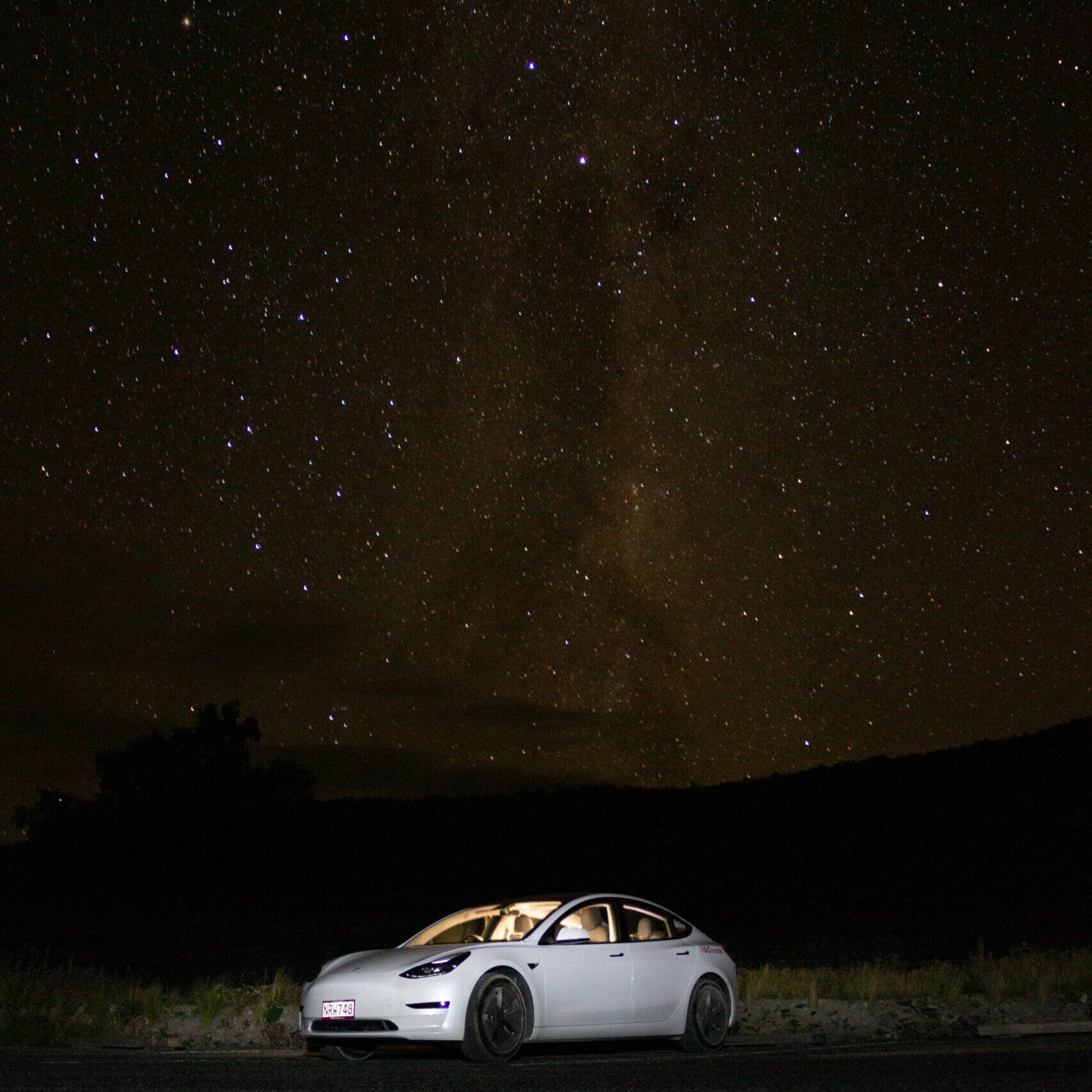 Photo of a white car beneath a starry sky.