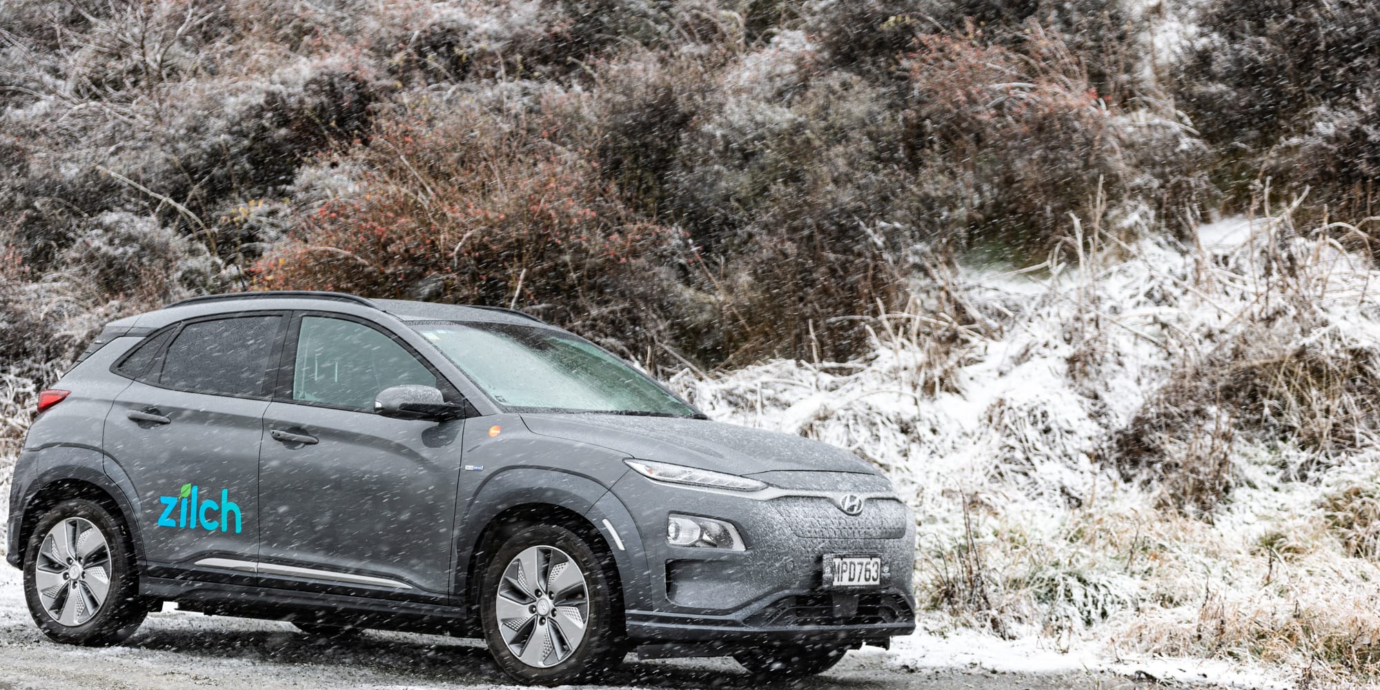 Photo of a grey Hyundai Kona (with blue Zilch logo) in the snow.